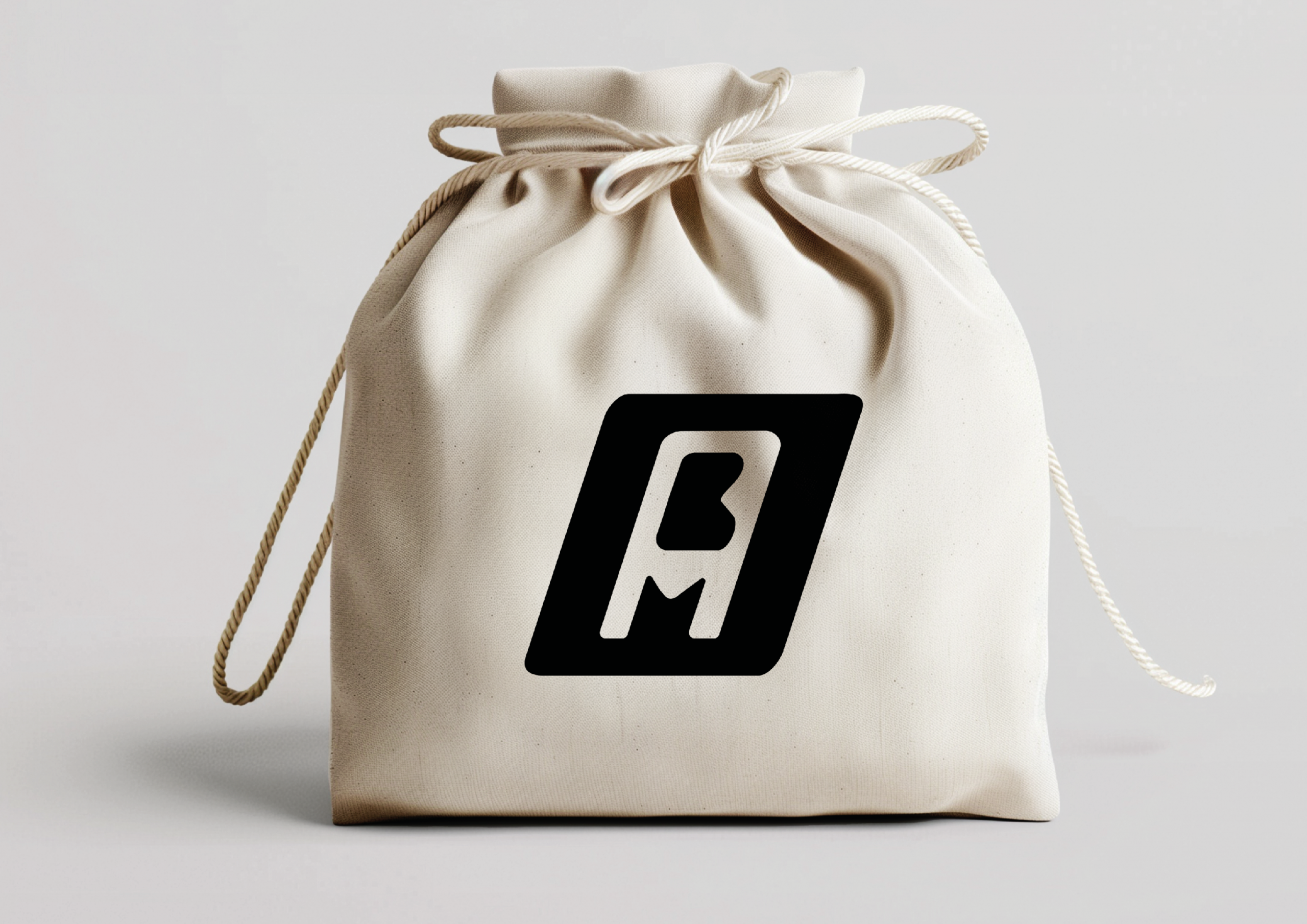 Mockup d’une pochette beige avec le logo noir de Bomart Marina ANASSOU, créatrice digital.